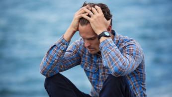 Depressed man in blue and brown plaid shirt