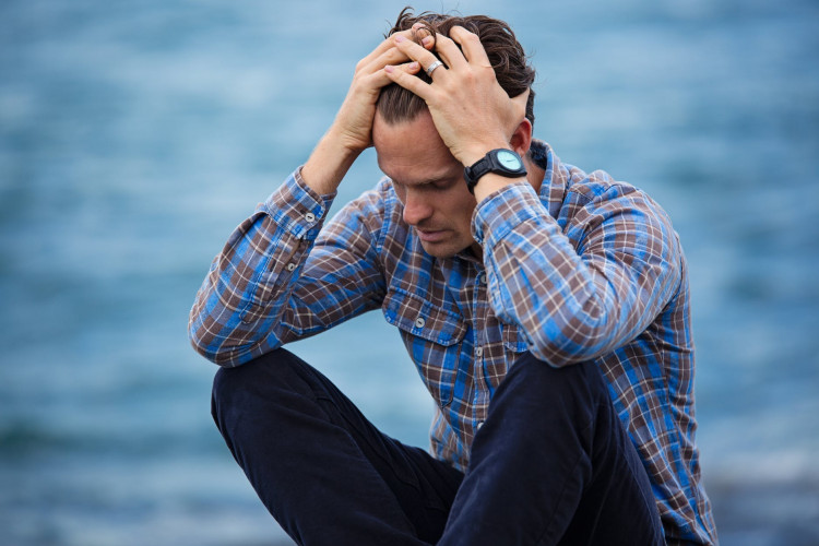 Depressed man in blue and brown plaid shirt