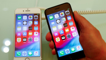 An employee of German Apple retailer Gravis displays an iPhone 7 and 8 in a store in Berlin