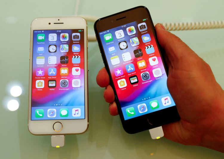 An employee of German Apple retailer Gravis displays an iPhone 7 and 8 in a store in Berlin