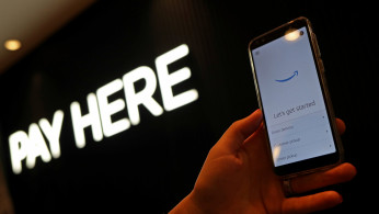 An employee holds a device used for Amazon Counter, a click and collect service allowing customers to collect their Amazon parcels in-store at a Next store in London