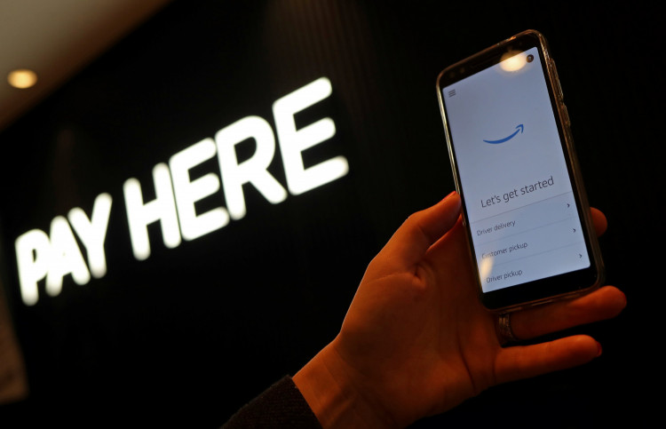 An employee holds a device used for Amazon Counter, a click and collect service allowing customers to collect their Amazon parcels in-store at a Next store in London