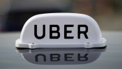The Logo of taxi company Uber is seen on the roof of a private hire taxi in Liverpool