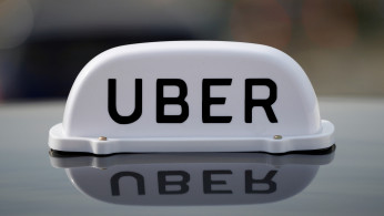 The Logo of taxi company Uber is seen on the roof of a private hire taxi in Liverpool