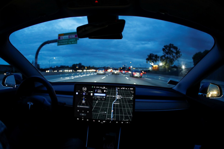 A Model 3 Tesla vehicle navigates morning rush hour using the car's auto pilot feature in Los Angeles