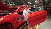 Ford Motor assembly worker works on a Ford Mustang vehicle
