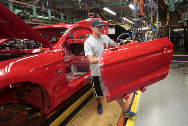 Ford Motor assembly worker works on a Ford Mustang vehicle
