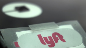 Uber and Lyft stickers are seen on a car windscreen as protesters join an Uber drivers' strike for higher wages at LAX airport in Los Angeles