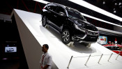 A worker stands near Mitsubishi Pajero Sport on display at the Indonesia International Motor Show in Jakarta