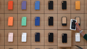 An Apple Store employee takes an iPhone product out of a drawer during the grand opening and media preview of the new Apple Carnegie Library store in Washington