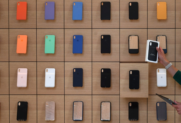 An Apple Store employee takes an iPhone product out of a drawer during the grand opening and media preview of the new Apple Carnegie Library store in Washington