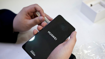 A salesman turns on a new Huawei P30 smartphone for a customer in Beijing