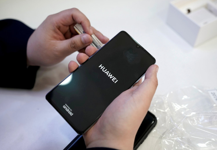 A salesman turns on a new Huawei P30 smartphone for a customer in Beijing