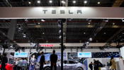 People visit a Tesla booth during the media day for the Shanghai auto show in Shanghai