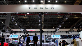 People visit a Tesla booth during the media day for the Shanghai auto show in Shanghai