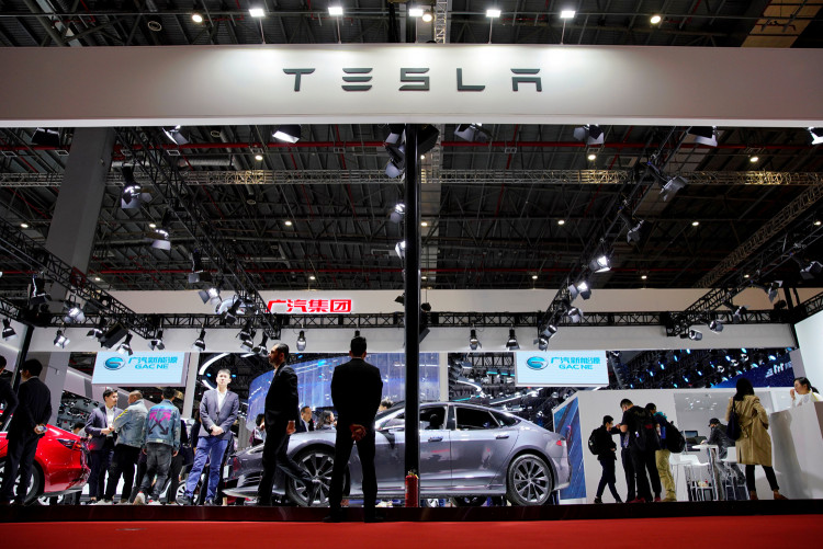 People visit a Tesla booth during the media day for the Shanghai auto show in Shanghai