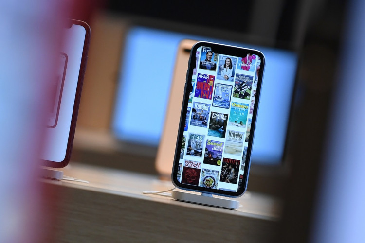 Front pages of newspapers and magazines are displayed on an iPhone during the grand opening and media preview of the new Apple Carnegie Library store in Washington