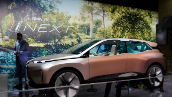 Man stands next to a BMW's Vision iNEXT displayed during the media day for Shanghai auto show