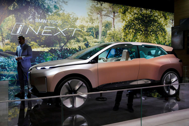 Man stands next to a BMW's Vision iNEXT displayed during the media day for Shanghai auto show