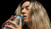 woman holding a plastic water bottle