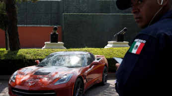 A police officer stands near a Chevrolet Corvette Stingray