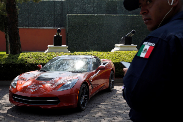 A police officer stands near a Chevrolet Corvette Stingray