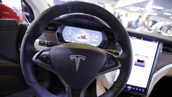 The logo of Tesla carmaker is seen inside a car at the Top Marques fair in Monaco