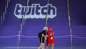 Attendees walk past a Twitch logo painted on stairs during opening day of E3, the annual video games expo revealing the latest in gaming software and hardware in Los Angeles