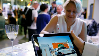 A man holds an iPad at Israeli energy storage firm Chakratec's exhibition stall at EcoMotion conference in Tel Aviv