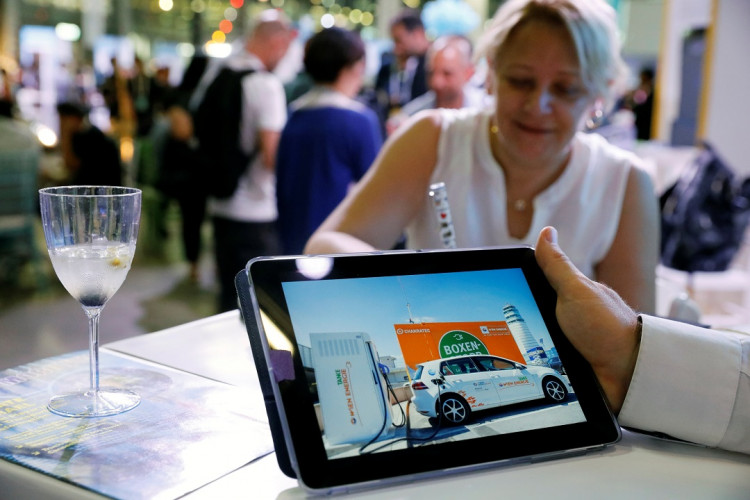 A man holds an iPad at Israeli energy storage firm Chakratec's exhibition stall at EcoMotion conference in Tel Aviv