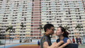 A couple take a selfie in front of Choi Hung estate, an apartment complex that became famous because of the rainbow color paints in Hong Kong
