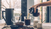 A person filling a mug with coffee