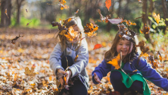 Children playing with dry leaves.