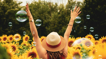 Happy woman surrounded by flowers.