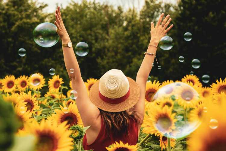 Happy woman surrounded by flowers.