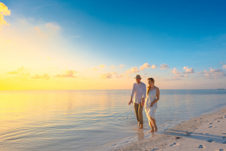 Couple Walking on Seashore During Sunset