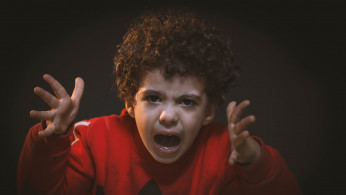 Angry toddler wearing adidas shirt.