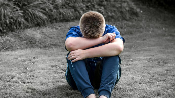 Rear view of a boy crying. 