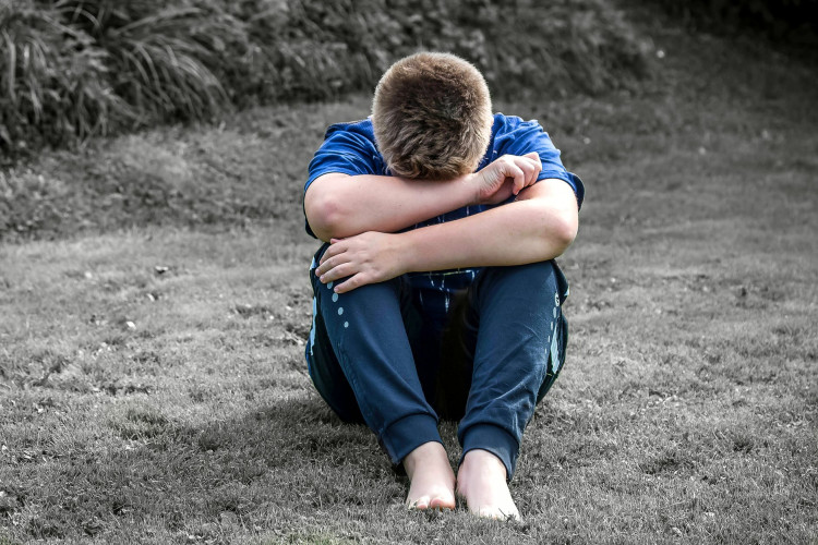 Rear view of a boy crying. 