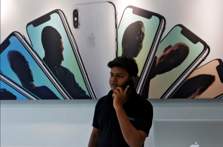 Salesperson speaks on the phone at an Apple reseller store in Mumbai