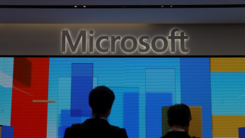Visitors stand in front of a display screen at Microsoft's new Oxford Circus store ahead of its opening in London