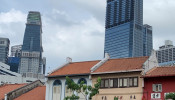 Tanjong Pagar Centre rises above a row of shophouses in Singapore