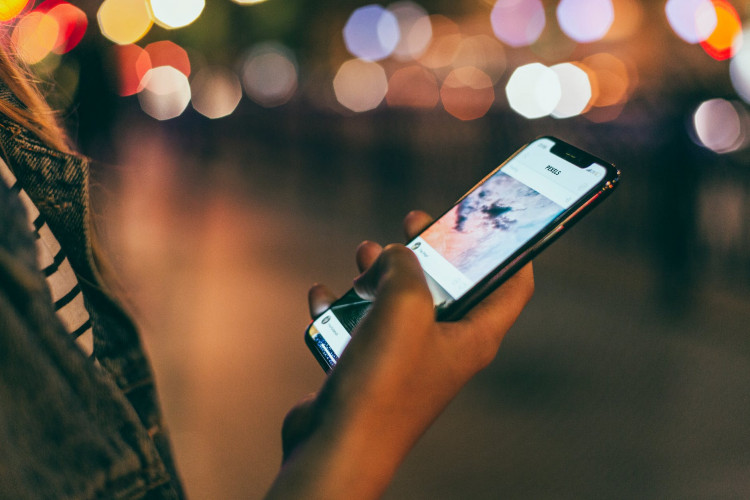 A girl holding Space Gray Iphone X.