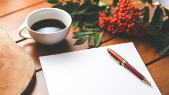 Blank paper with pen and coffee on the table.