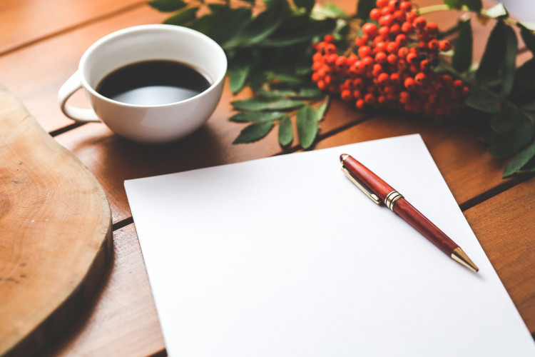 Blank paper with pen and coffee on the table.