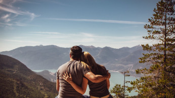 Man and woman sitting on a bench enjoying a fantastic view.