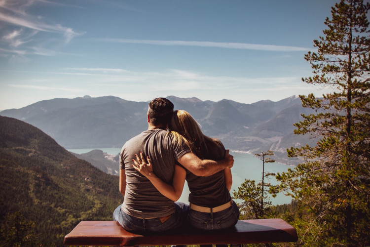 Man and woman sitting on a bench enjoying a fantastic view.