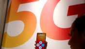 An employee displays a Huawei 5G Smartphone Mate 20X smartphone at a Sunrise telecommunications shop in Opfikon