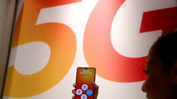 An employee displays a Huawei 5G Smartphone Mate 20X smartphone at a Sunrise telecommunications shop in Opfikon