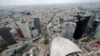 French Army helicopters fly over La Defense business district on their way to participate to the traditional Bastille Day military parade